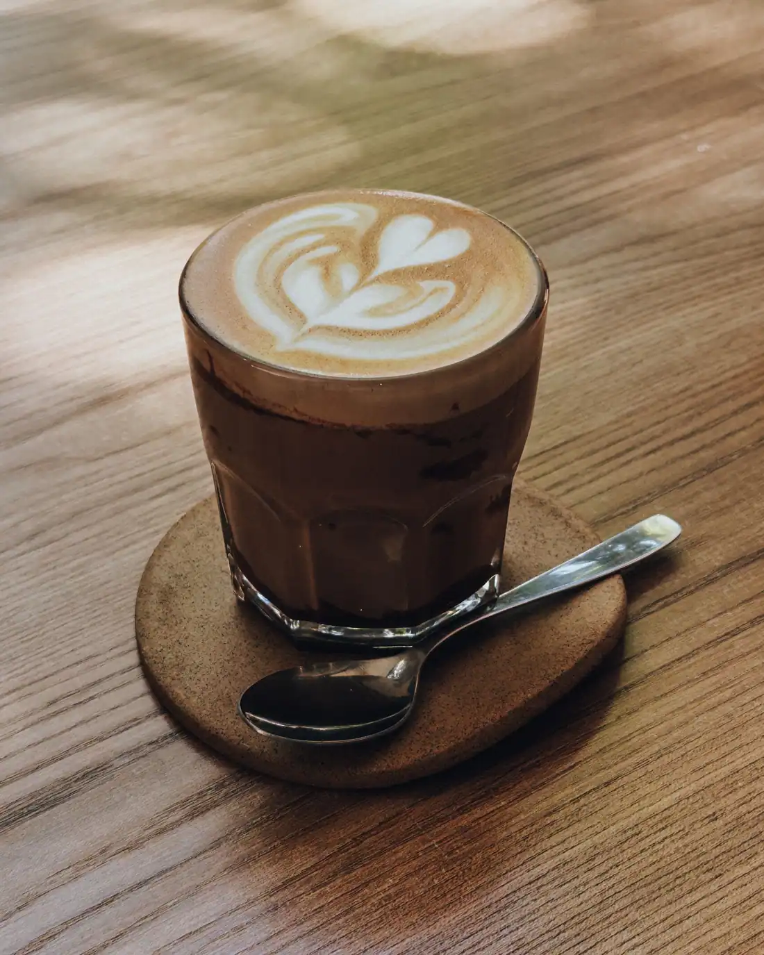 Latte in a glass on a wooden table