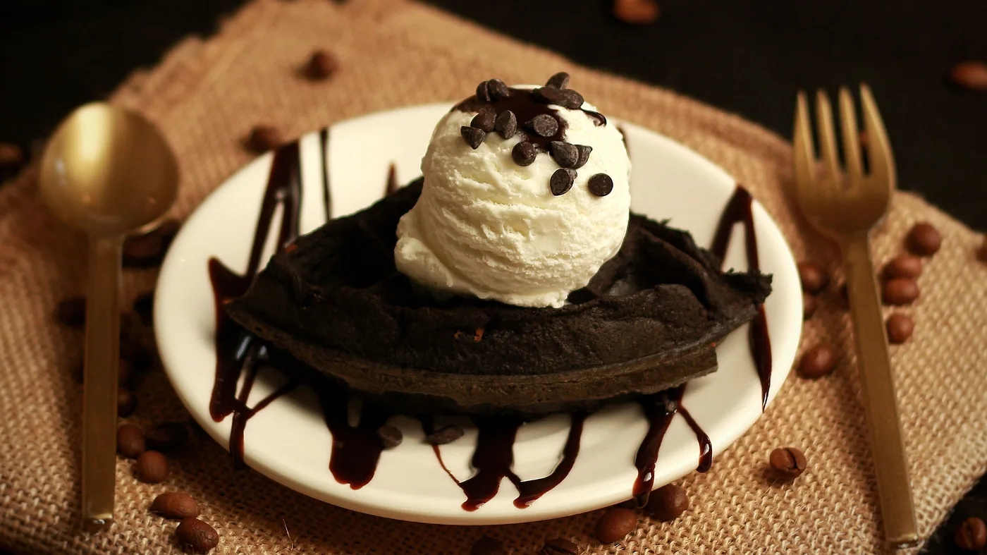 Chocolate dessert with a scoop of ice cream and chocolate sauce, on burlap with coffee beans